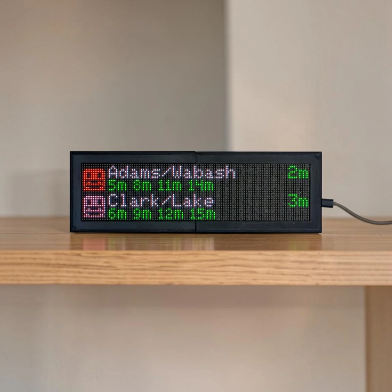 CommuteLive display on an oak shelf showing Chicago CTA arrivals